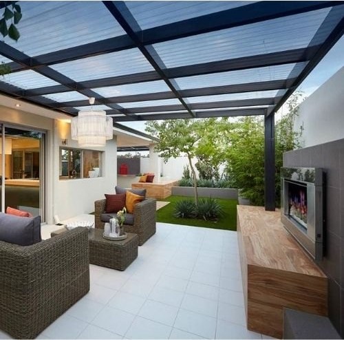 An outside conservatory with a garden in the background and a twinwall polycarbonate roof.