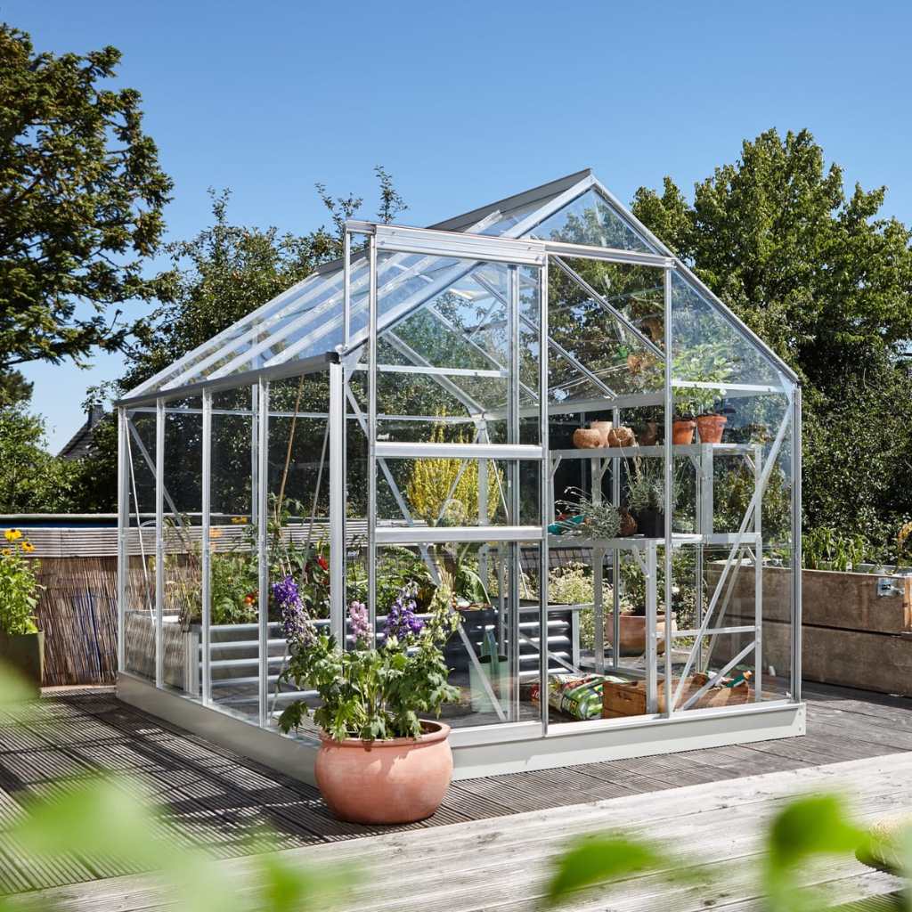 A glass greenhouse with plants inside.
