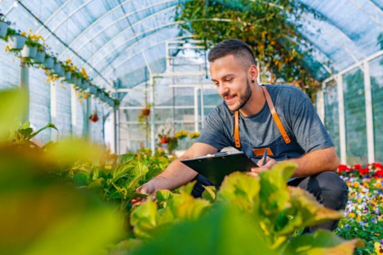 A man gardening inside of a greenhouse.