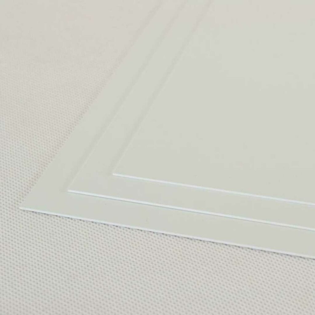 Stacked sheets of white E-clad PVC.
