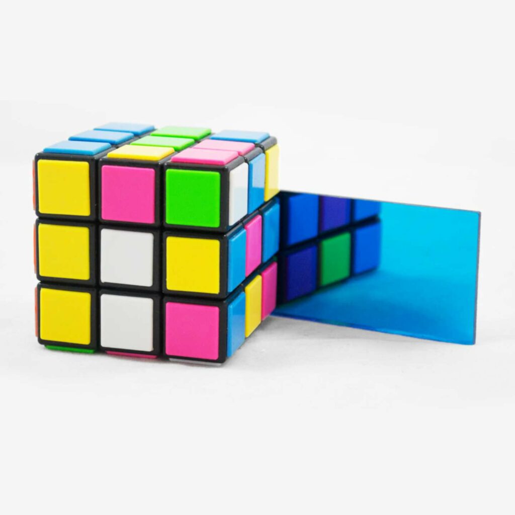 A blue mirrored sheet next to a rubix cube.
