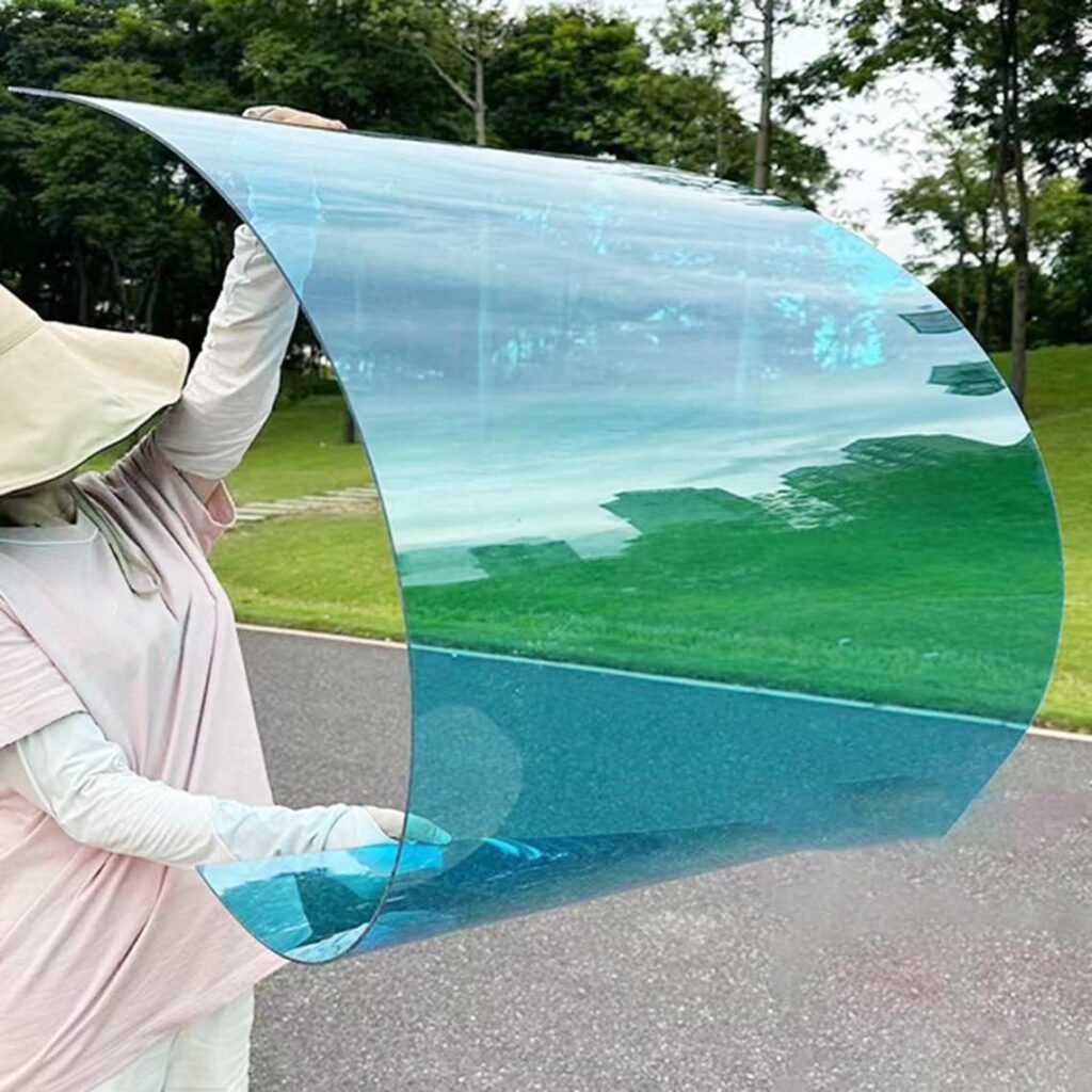 A person holding a blue transluscent sheet that is bent.
