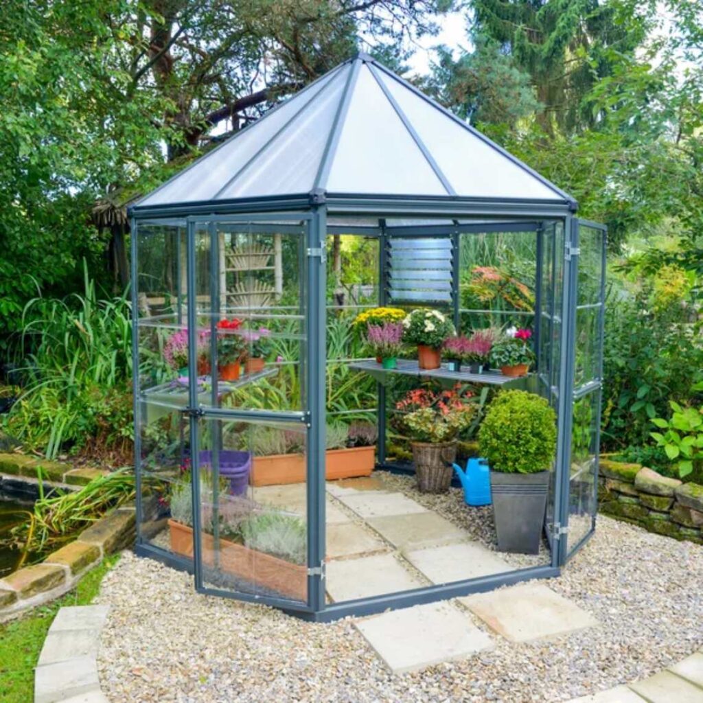 An acrylic greenhouse in a garden.